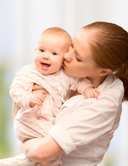 Happy cheerful family. Mother and baby kissing