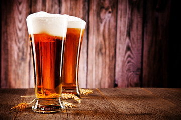 Glasses of beer on wooden table