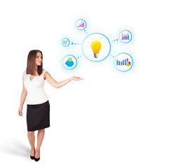 Young woman presenting light bulb with colorful graphs and diagr