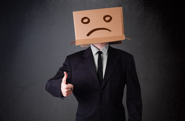 Young man with a brown cardboard box on his head with sad face