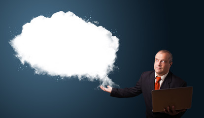 Businessman holding a laptop and presenting abstract cloud copy