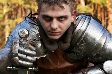 Knight holding sword in a forest.