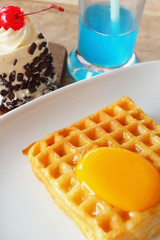 Waffle topped with eggs and cake