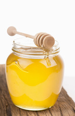 Honey in bank on wooden boards isolated by the white