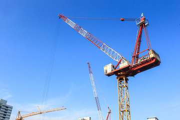 cranes at the construction site against blue sky
