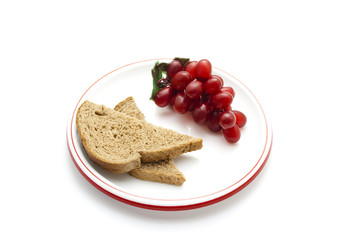 Plastik Trauben mit Vollkornbrot auf Teller