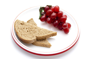 Plastik Trauben mit Vollkornbrot auf Teller