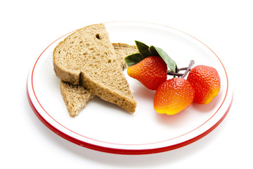 Vollkornbrot mit Plastik Erdbeeren auf Teller