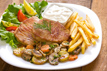 Pork chop with French fries and vegetables