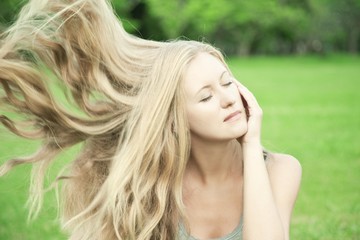 A girl with long blond hair on the nature