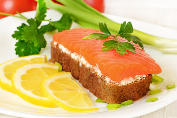 Sandwich with salmon, lemon slices and parsley