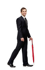 Walking man with closed red umbrella, isolated