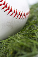 Angled macro shot of smudged baseball in grass