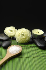 Fototapeta na wymiar Two ranunculus flower, salt in spoon with zen stone on mat