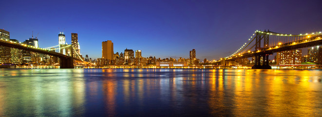 VIew of Manhattan and Brooklyn bridges and skyline at night