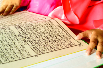 A Young Muslim Girl reading the Holy Quran.