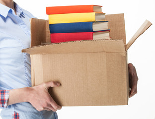 Student holding a big box with stack of books