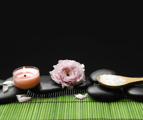 Obraz na płótnie Canvas Pink ranunculus with candle ans salt in spoon on green mat