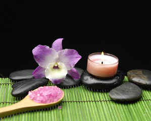 Lying down orchid with zen stone and candle on mat