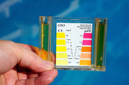 Holding a pool analysis kit  by pool © Arena Photo UK