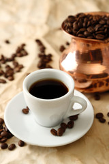 Obraz na płótnie Canvas Cup and pot of coffee on beige background