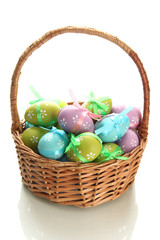 Bright easter eggs with bows in basket, isolated on white