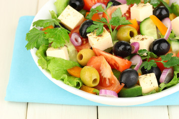 Fresh salad in plate on wooden table