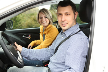 Portrait of young beautiful  couple sitting in the car