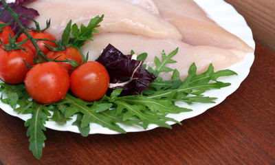 tomatoes and raw chicken meat with ruccola