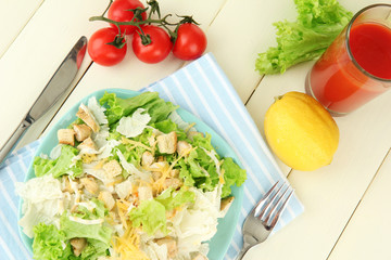 Caesar salad on blue plate, on color wooden background
