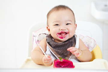 Baby eating dragon fruit