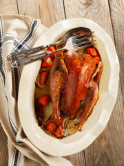Baked pheasant in red wine with carrot and onion