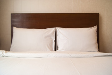 two white pillows over white bed with nobody