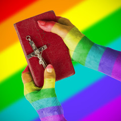 Old hands holding a very old bible, rainbow flag pattern © michaklootwijk