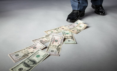 Men's feet and dollar banknotes on the floor