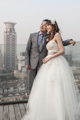 Fototapeta premium bride and groom standing ouside with shanghai jingguang waitan