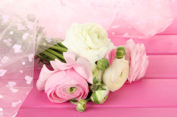 Ranunculus (persian buttercups), on pink wooden  background