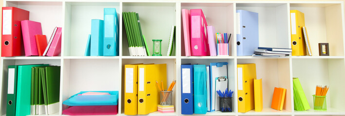 White office shelves with different stationery, close up