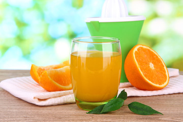 Glass of juice, citrus press and ripe orange
