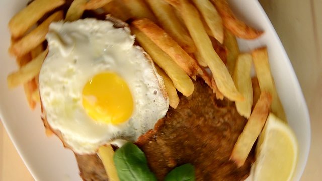 Milanesa con fritas y huevo