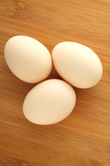 Three eggs on wooden background