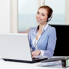 Junge blonde Frau arbeitet in einem callcenter mit headset