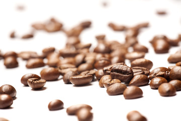 coffee beans, scattered on a white ground 