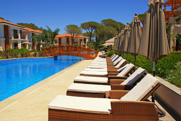 Beautiful poolside with line of chaise longues