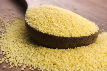 couscous in wooden spoon on kitchen table