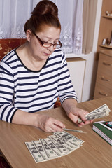 Senior woman counting savings money