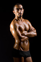 Muscular man in dark studio