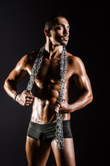 Fototapeta na wymiar Muscular man with chain on black background