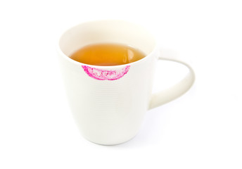 Red lipstick mark on a white tea cup isolated