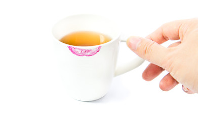 Red lipstick mark on a white tea cup isolated
